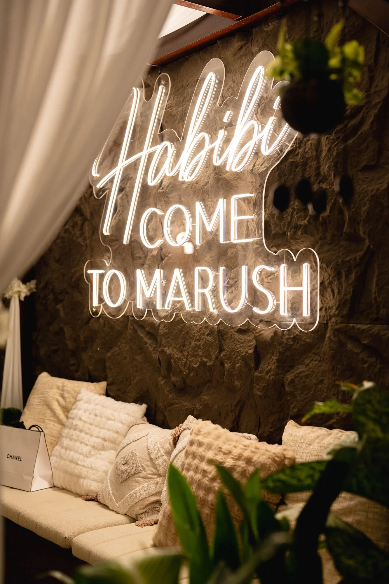 Intimate lounge seating under the Marush neon sign.