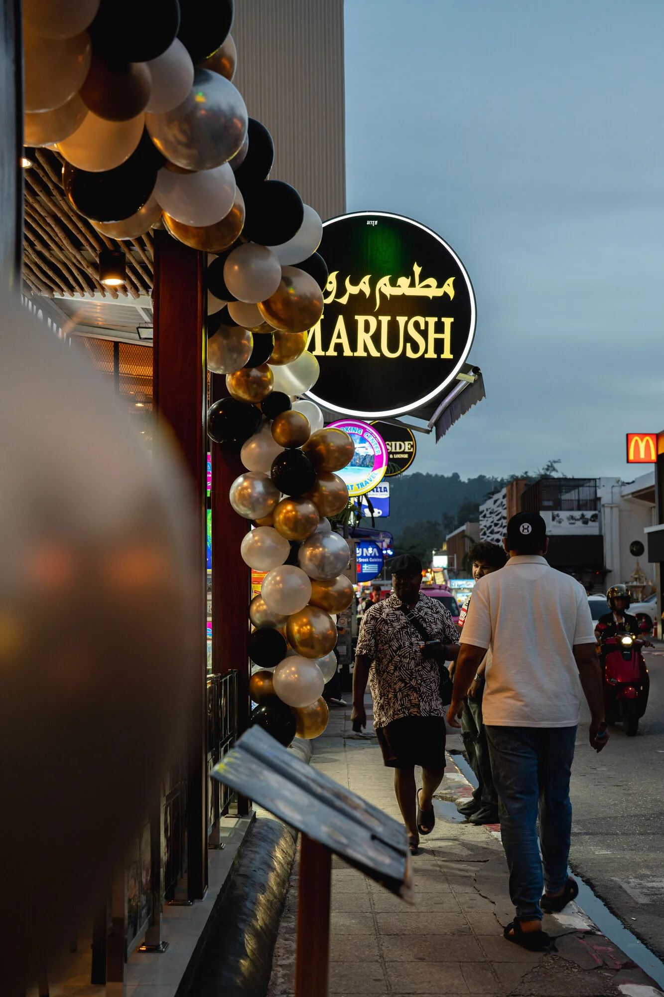 Marush storefront at dusk decorated with a balloon arch.