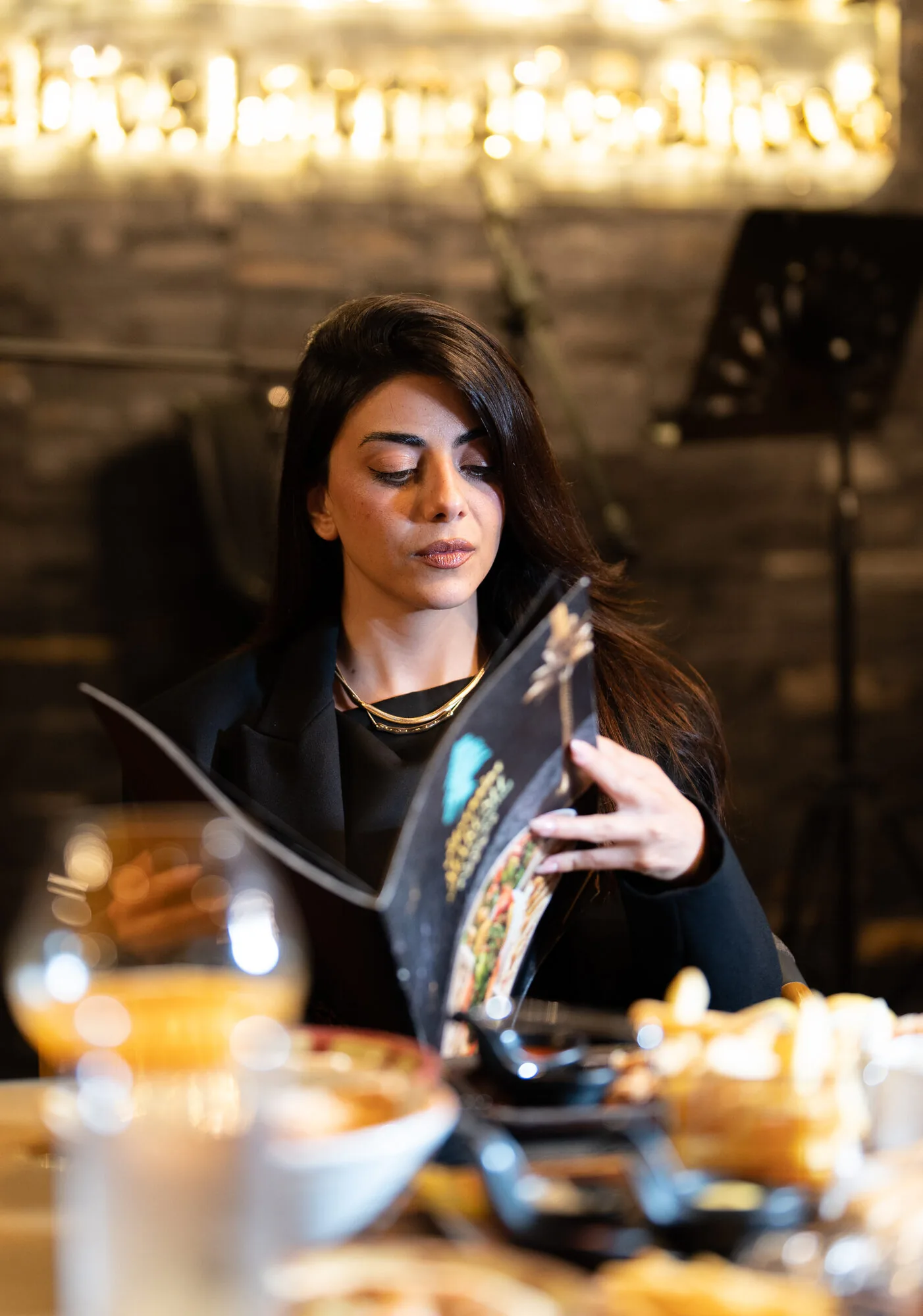 Guest reading the menu in Marush's warm, candle-lit dining room.