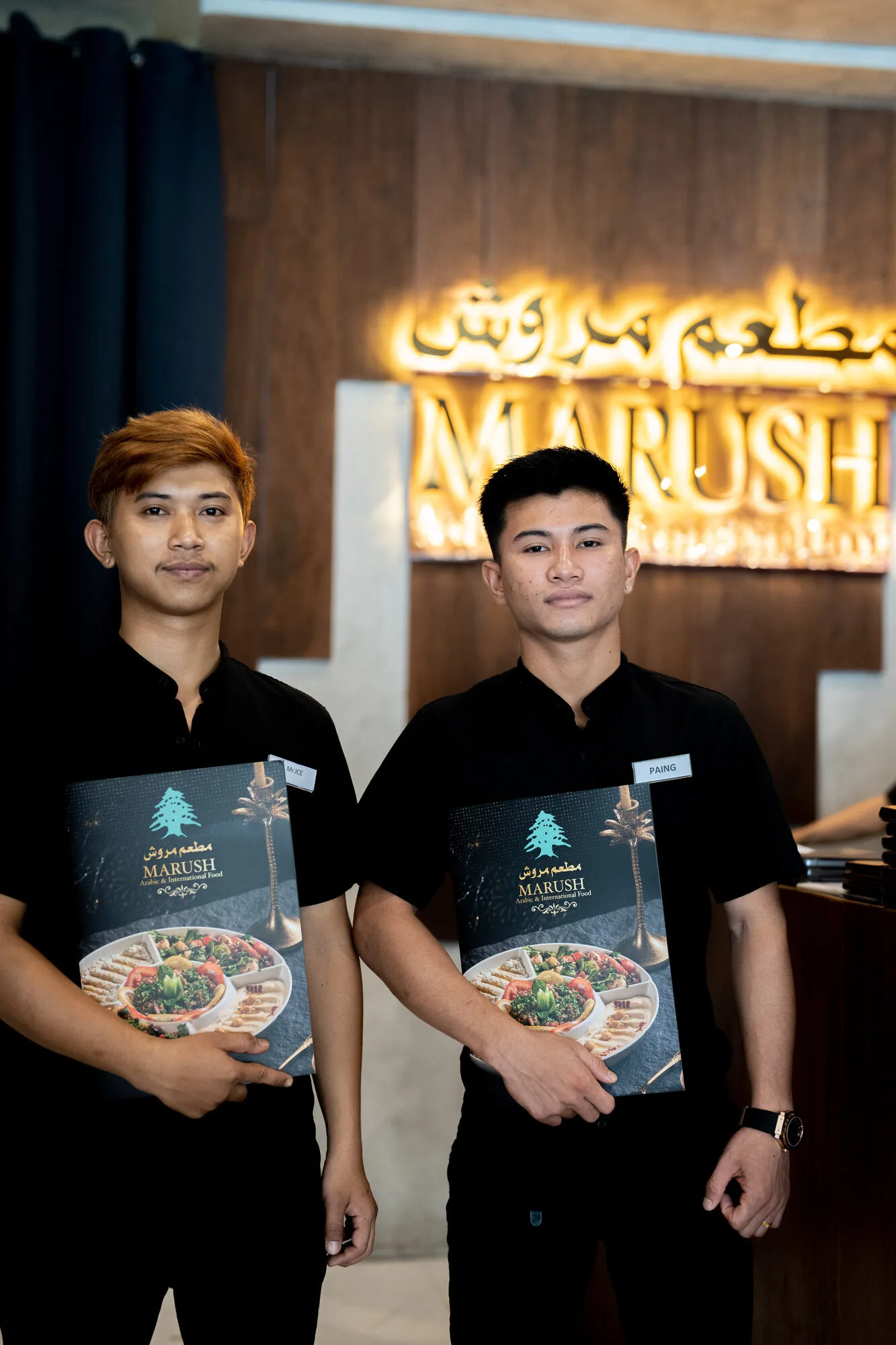 Marush waiters welcoming guests with menus.